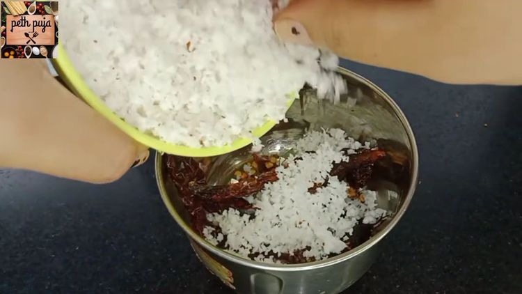 Step 1.1: Transfer the roasted spices to a mixie jar, add tamarind and shredded coconut, and grind into a fine paste