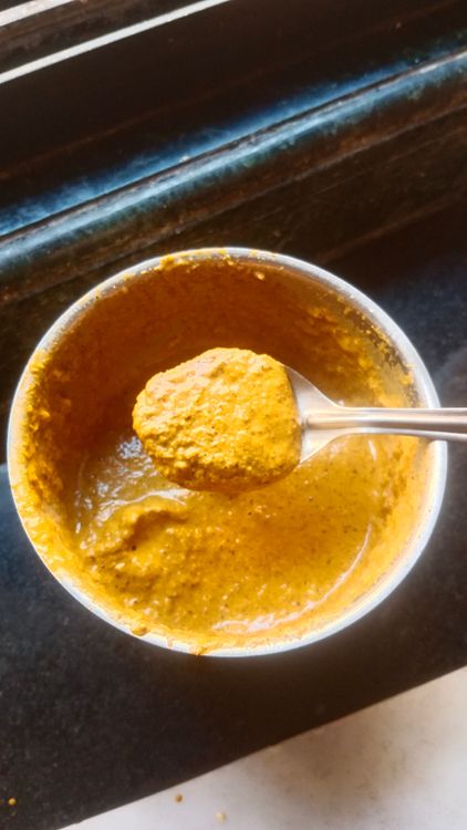 Step 1.1: In a mixie jar, grind shredded coconut, dry red chilli, coriander seeds, tamarind, turmeric powder, garlic pods, and water into a fine paste