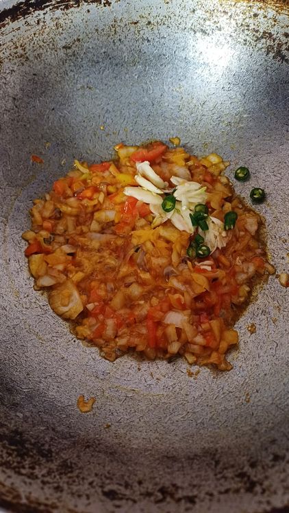 Step 1.2: In the same pan, heat groundnut oil and add finely chopped onion, tomato, green chillies, crushed garlic, and finely chopped ginger