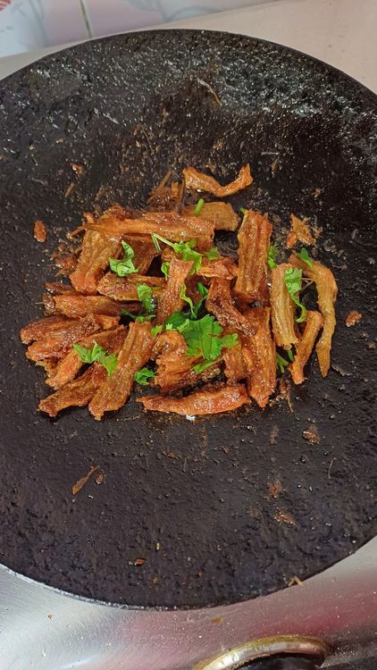 Step 1.1: Turn off the flame, squeeze some lemon juice over the fried bombil, and garnish with chopped coriander leaves