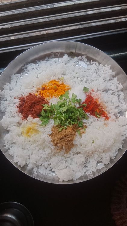 Step 1.1: Take the leftover cooked rice and add turmeric powder, salt, kashmiri red chilli powder, coriander powder, asafoetida, goda masala, and chopped coriander leaves