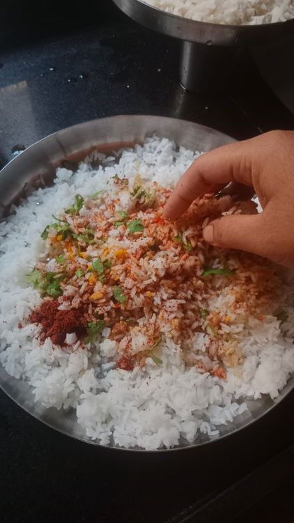 Step 1.2: Take the leftover cooked rice and add turmeric powder, salt, kashmiri red chilli powder, coriander powder, asafoetida, goda masala, and chopped coriander leaves