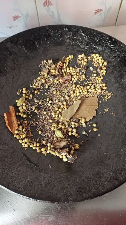 Step 2.1: Mix cumin seeds, mustard seeds, poppy seeds, fenugreek seeds, coriander seeds, black pepper corns, cloves, cinnamon stick, bayleaf, stone flower, and tamarind piece on a plate