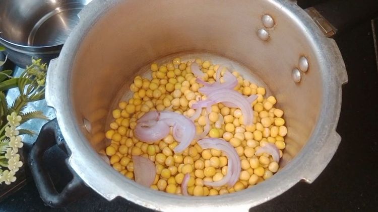 Step 1.1: Transfer the soaked peas to a pressure cooker, add 1 chopped onion, salt, and 3 cups of water