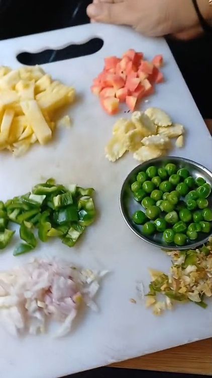 Step 1.1: Toss in finely chopped onion, sliced baby corn, diced carrot, and green peas