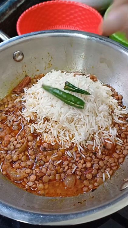 Step 1.1: Add the dal, green chillies and rice to the pan and mix well