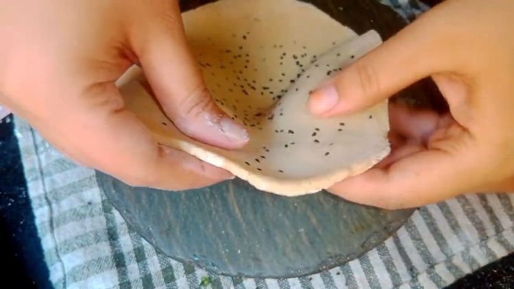 Step 1.2: Heat the tawa and roll the dough balls into 7-8 inch size in length
