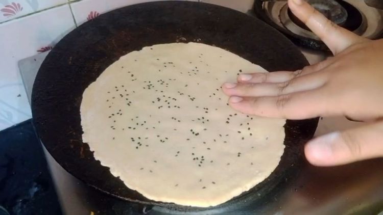 Step 1.1: Wet one side of the roti lightly with water and place the wet side down on a hot tawa (no oil)