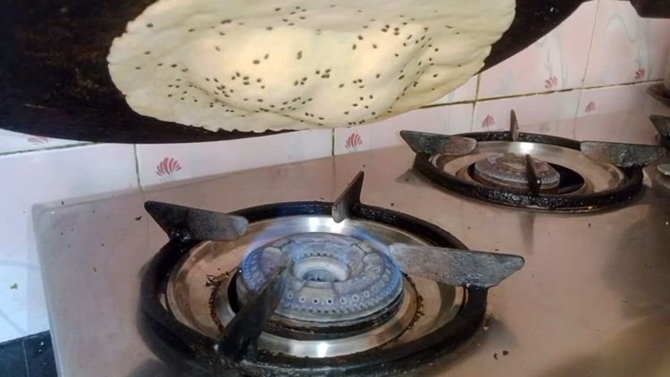 Step 1.2: Cook until bubbles appear and the roti sticks to the tawa
