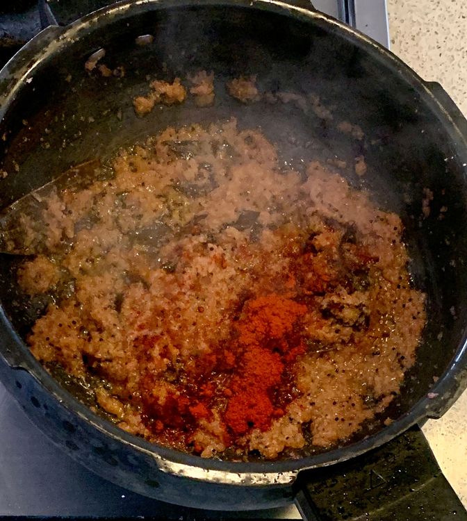 Step 1.1: Stir in the kashmiri red chilli powder and tomatoes to the mixture