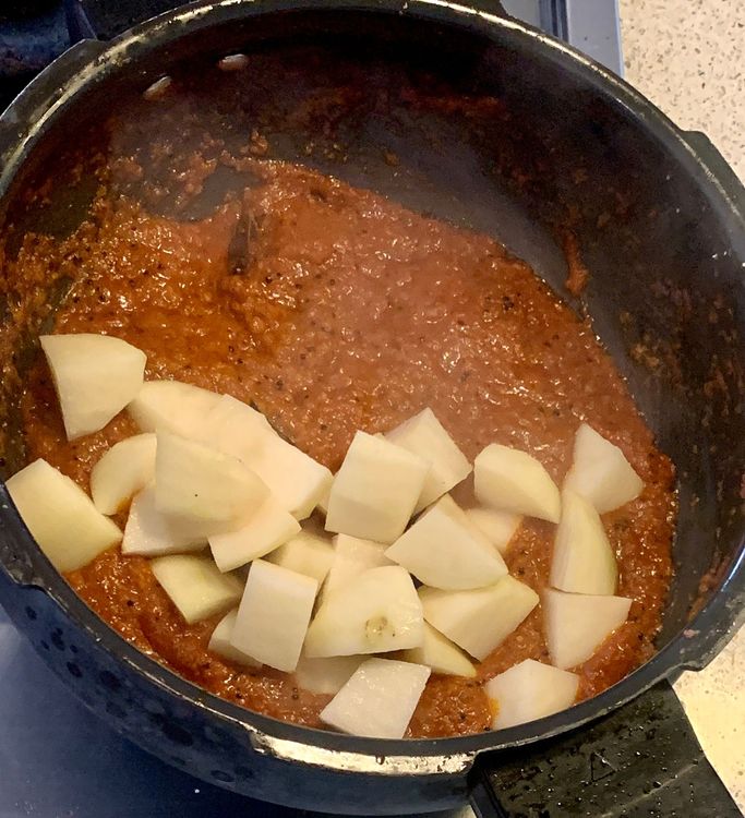 Step 1.1: Add the cubed potatoes to the curry and stir to coat them with the spice mixture