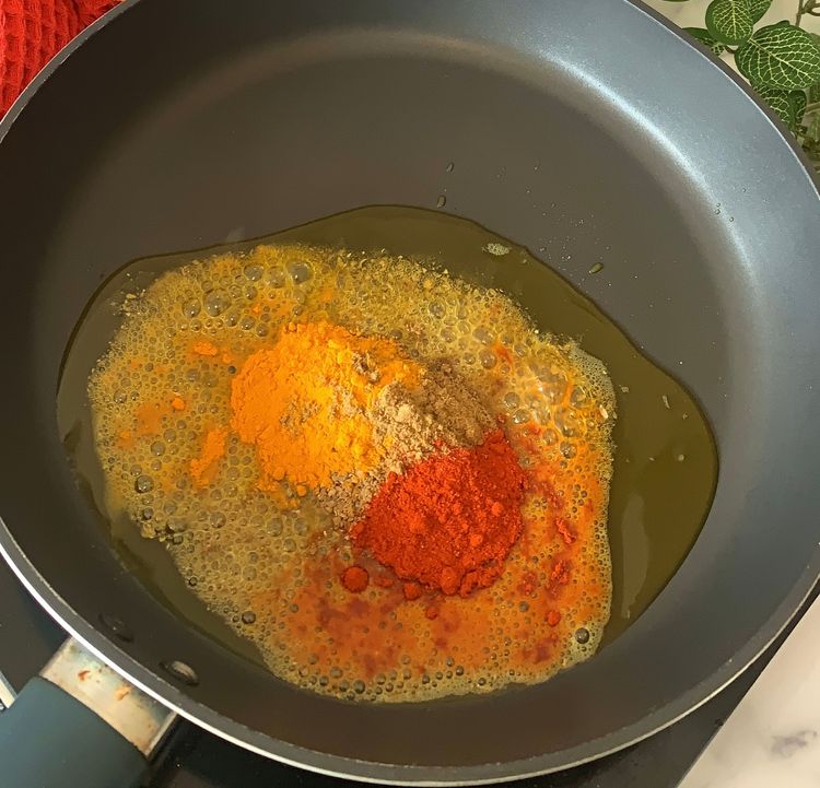 Step 2.1: Reheat oil on low-medium heat, add asafoetida, coriander powder, cumin powder, red chilli powder, and turmeric
