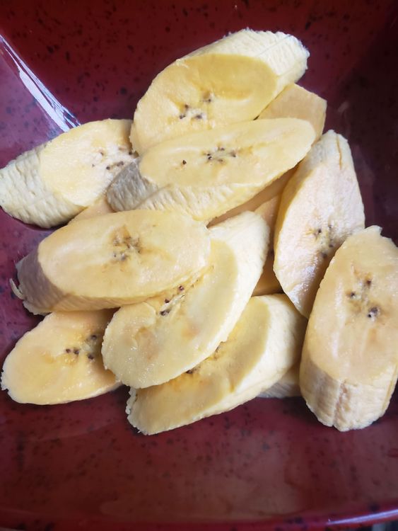 Step 1.1: Then you slice the plantain horizontally but in a slanty way (please refer to my video to see how) and add a pinch of salt