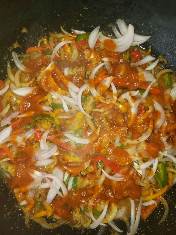 Step 1.1: After slicing your bell peppers and onions, you add little oil in a non stick pan, add your veggies then stir, add your chicken ( preferably diced) then and your spices and stir