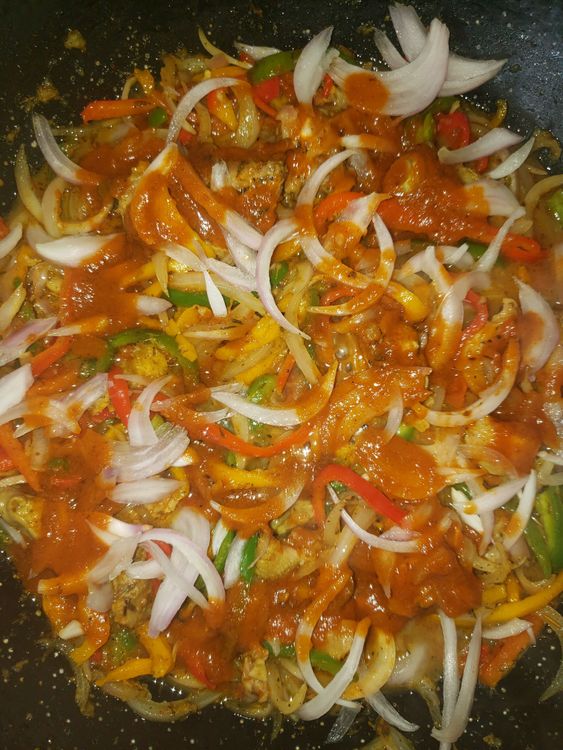 Step 1.2: After slicing your bell peppers and onions, you add little oil in a non stick pan, add your veggies then stir, add your chicken ( preferably diced) then and your spices and stir