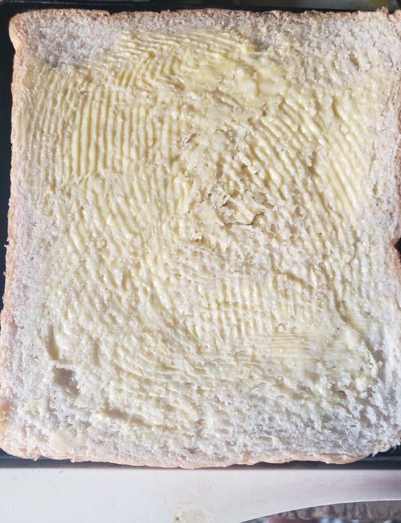Step 3.1: Place one slice of buttered bread on the sandwich maker
