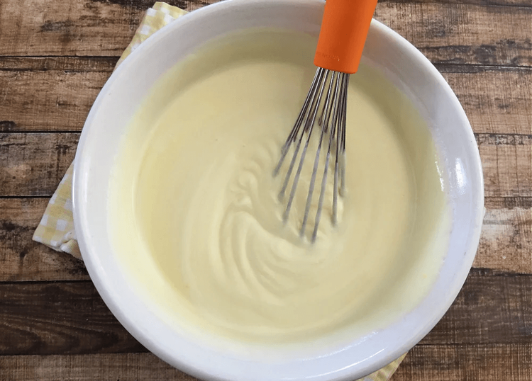 Step 2.1: Pour half of the pudding mixture over the vanilla wafers and banana slices in the trifle dish