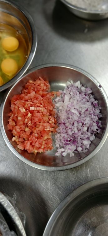 Step 1.1: Add the chopped onions and tomatoes to the bowl