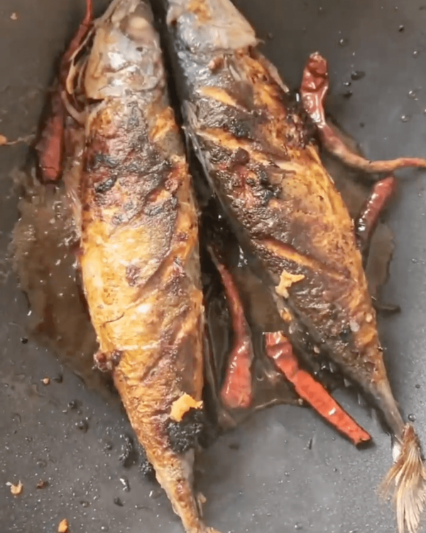 Step 1.1: Pan fry the seasoned mackerel in coconut oil with ground ginger, garlic, and dried chillies for 2 minutes on each side until the skin is crispy and golden brown