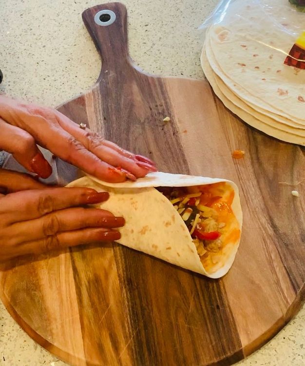 Step 1.1: Add grated cheese on top and wrap the tortilla from three sides