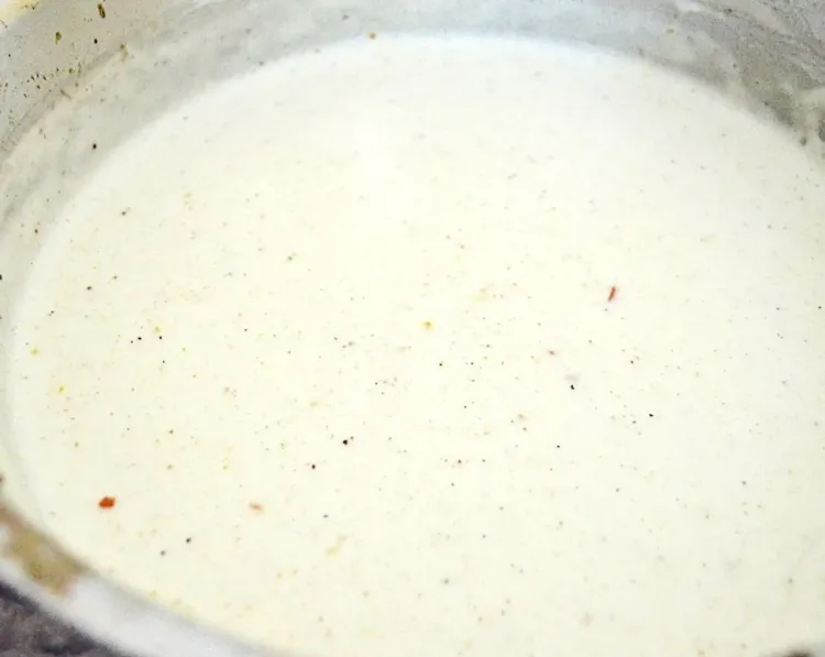Step 2.1: Slowly pour in the Milk while whisking until you have a smooth white sauce