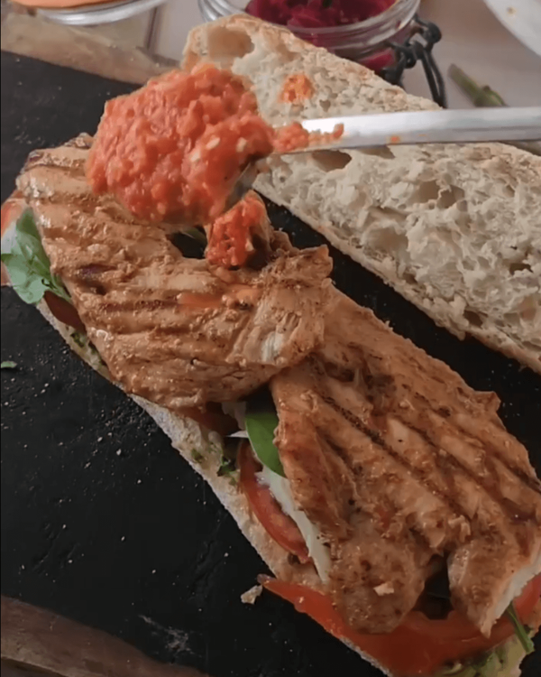 Step 3.1: Place sliced grilled chicken on the basil leaves and spread spicy red pepper sauce over the chicken