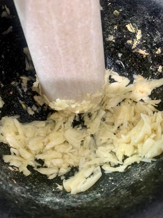 Step 1.1: Reheat the oil on low-medium heat, add asafoetida and the crushed garlic, and saute for 2-3 minutes until slightly golden
