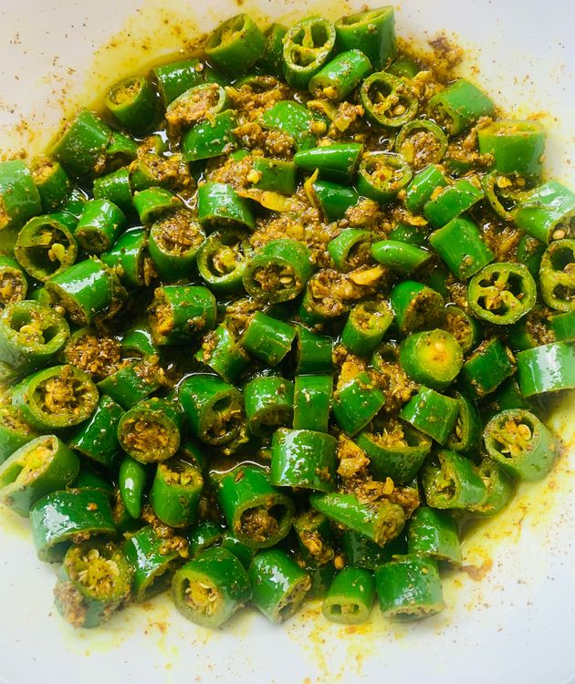 Step 1.3: Add the spiced green chillies to the pan and mix well to combine with the oil and garlic