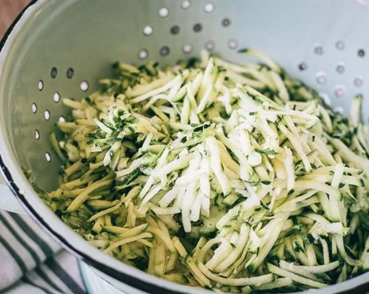 Step 1.1: Add grated zucchini to a food processor, then transfer to a strainer