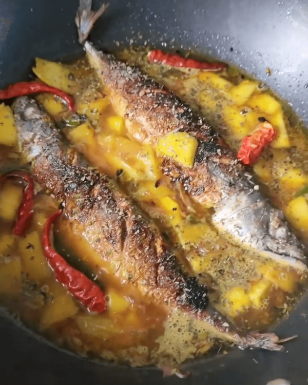 Step 2.1: Add chopped green mangoes and a cup of water or enough to just cover the fish