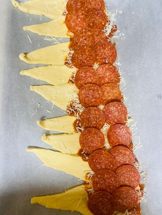 Step 1.1: Layer Ingredients: Spread a thin layer of marinara sauce over each dough rectangle, leaving a 1-inch border around the edges