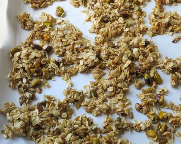 Step 4.1: Divide the granola between the two sheet pans and spread it out into a single layer