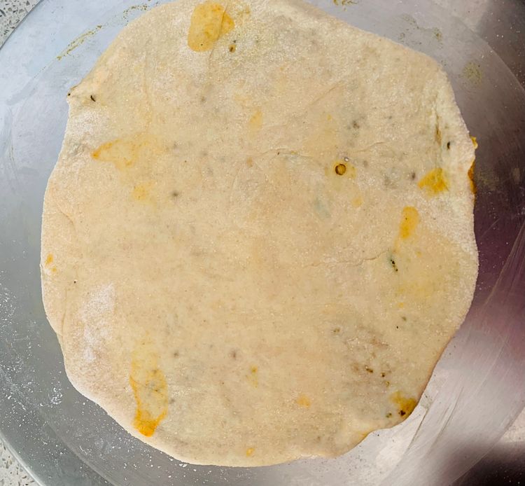 Step 2.1: Dust some flour on the stuffed dough ball and roll it out gently into a circular paratha