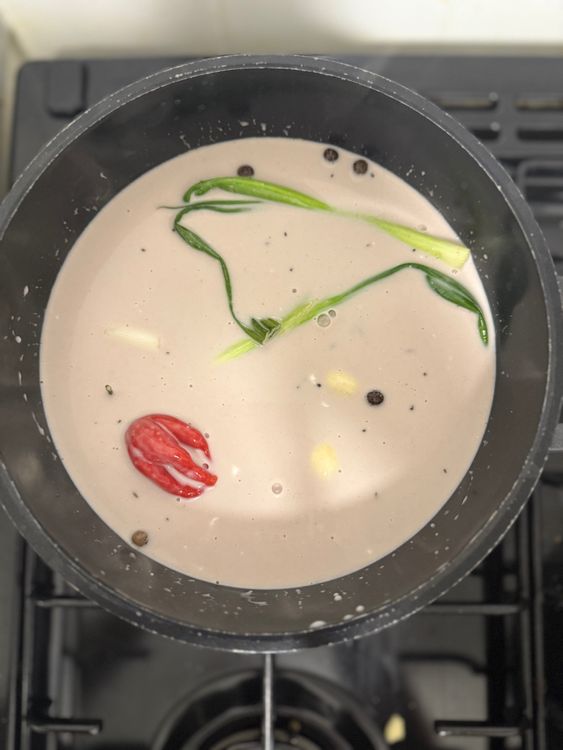 Step 3.2: In a pan, combine kidney beans (undrained), coconut milk, thyme, pimento, all-purpose seasoning, spring onions, garlic, scotch bonnet, salt, black pepper, and water