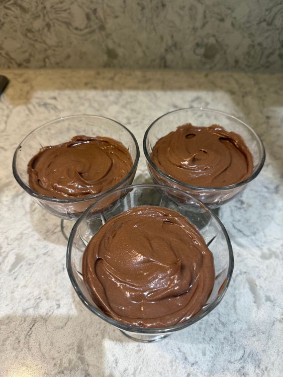 Step 4.1: Remove the biscuit bases from the fridge and spoon on the Nutella layer first