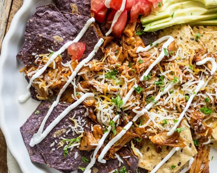 Step 4.1: Once the jackfruit is ready, evenly divide it between two plates on a bed of tortilla chips