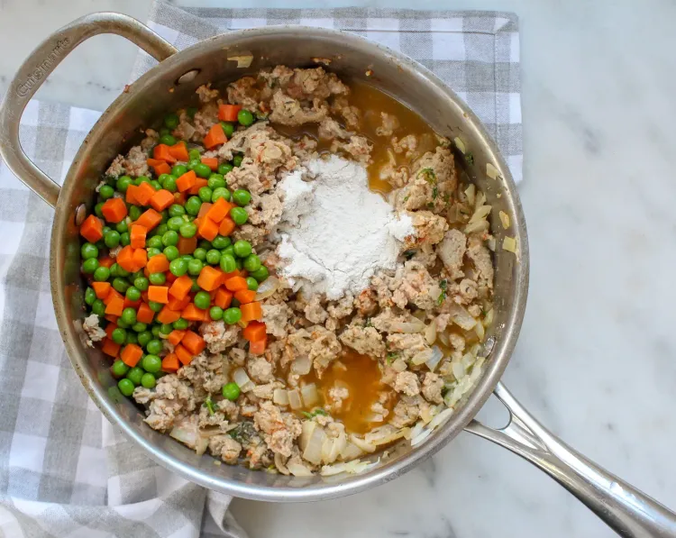 Step 1.1: Add the all-purpose flour, chicken broth, and thawed frozen peas and carrots