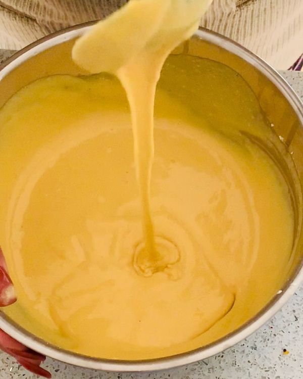 Step 1.2: Add gram flour (besan), semolina (suji), ginger, turmeric, sugar, salt, oil, and water to a mixing bowl