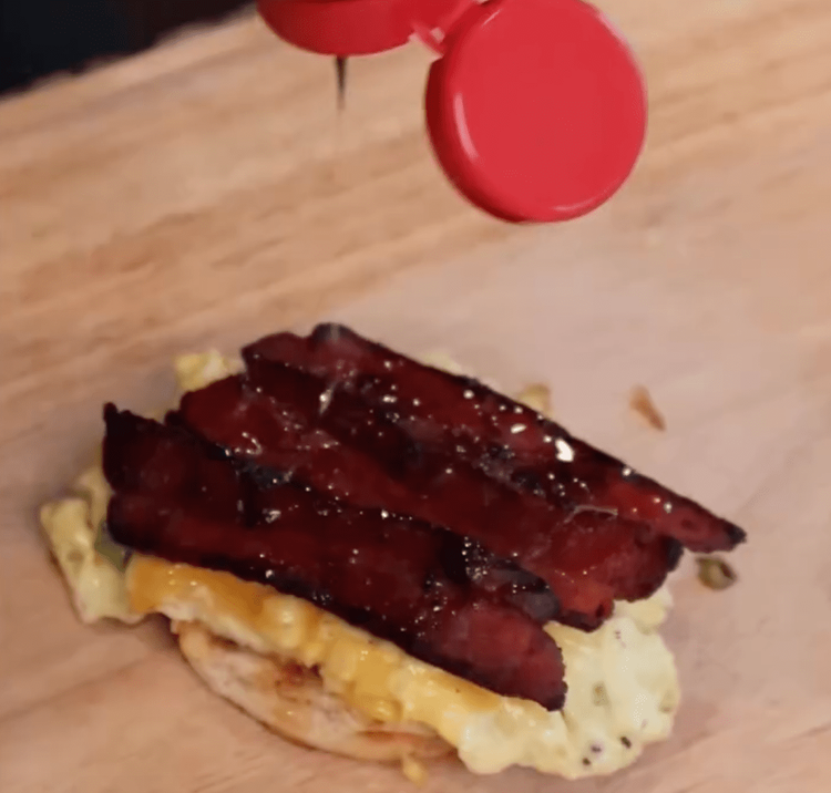 Step 1.1: Warm the biscuits, slice them open, and layer with bacon, cheesy eggs, and a drizzle of hot honey