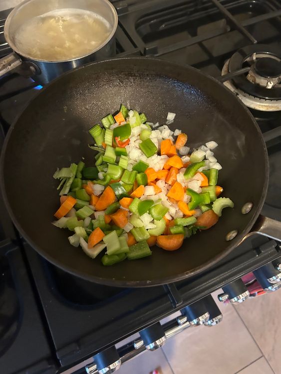 Step 1.1: Heat a pan over medium heat and add the chopped celery, carrots, bell pepper, and frozen onion