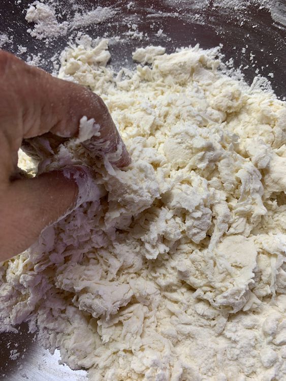 Step 1.1: Gradually add water, stirring with your hands or a spoon to form a soft dough