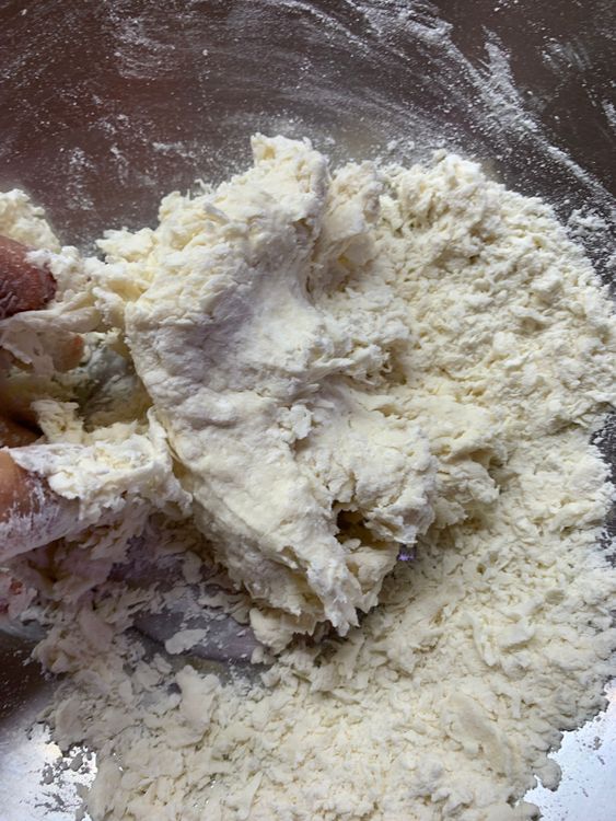 Step 1.2: Gradually add water, stirring with your hands or a spoon to form a soft dough