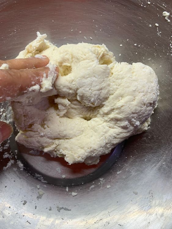 Step 1.3: Gradually add water, stirring with your hands or a spoon to form a soft dough