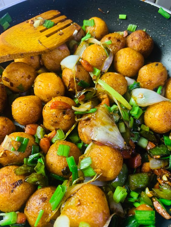 Step 2.2: Add the fried potato balls and chopped green stalks and toss them gently