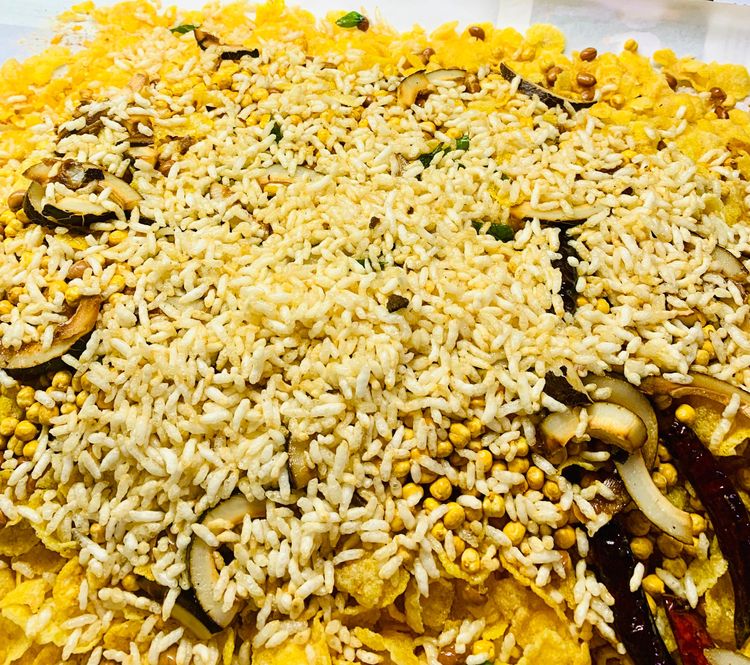 Step 2.3: Add puffed rice to the oil and fry for a few seconds before removing and placing them on the sieve