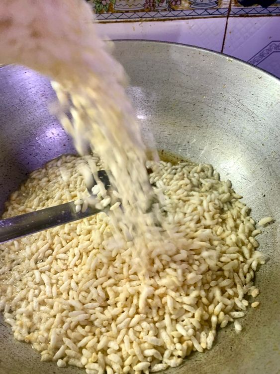Step 2.1: Add puffed rice to the oil and fry for a few seconds before removing and placing them on the sieve