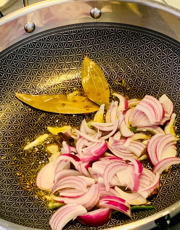 Step 1.1: Add sliced onion and green chillis to the pot and fry until pinkish