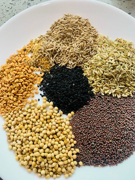 Step 1.1: In a dry pan, roast the mustard, fennel, coriander, cumin, nigella, fenugreek, and carom seeds for a few minutes until fragrant