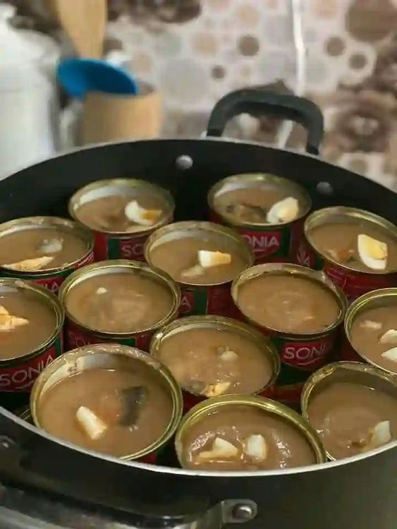 Step 4.1: Boil water in a kettle and pour it carefully into a larger pot, ensuring it does not enter the Moi Moi containers