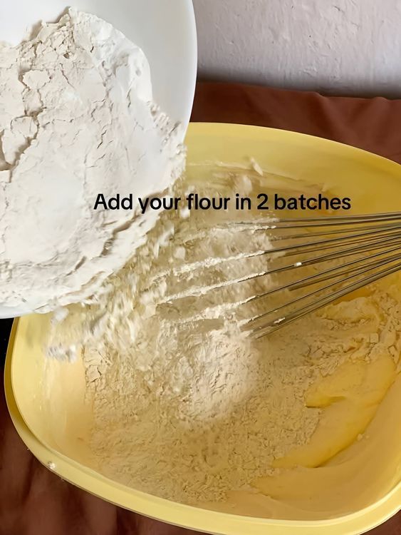 Step 1.1: Gradually add the flour and baking powder in two batches, folding gently to combine